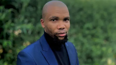 Esethu Dywili Accountant Esethu Dywili, dressed smartly in a blue suit, looks at the camera