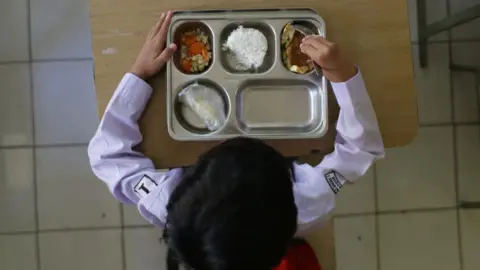 Indonesia food poisonings and protests test Probowo's first year in office Getty Images A student eats lunch on the first day of a free-meal programme at Kedung Badag 1 State Elementary School in Bogor, West Java, on January 6, 2025.