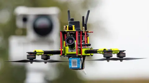 What's the best way to detect and destroy drones? AFP via Getty Images A small drone with four rotors, three aerials and a camera on the front flies in front of a detection device.