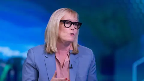 Our biggest competition is screens at home, says theme park boss Getty Images Fiona Eastwood pictured in 2025. She is wearing a blue pastel coloured blazer, a salmon coloured blouse, and thick-rimmed dark glasses, and she has blonde shoulder length hair. She appears to be mid-talking during an on stage interview event