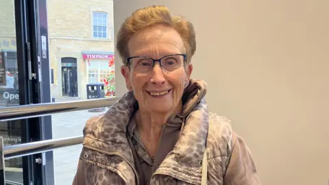 The new hubs saving Yorkshire towns from becoming banking deserts Kit Taylor/BBC A woman with short brown hair and glasses smiling at the camera.