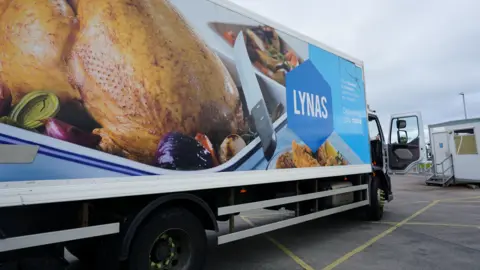 NI customers paying more post-Brexit, says catering firm boss A food truck with a photo of a roast chicken on the side. It says 'Lynas' with a blue logo.