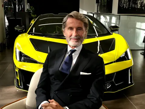 Lamborghini swerves away from all-electric future Lamborghini chief executive Stephan Winkelmann in a full suit, sat in front of a bright yellow Lamborghini Fenomeno