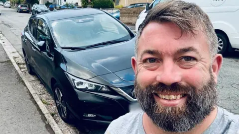 How to tell the health of a battery in a used EV Kerry Dunstan Bearded Kerry Dunstan stands in front of his black Nissan Leaf