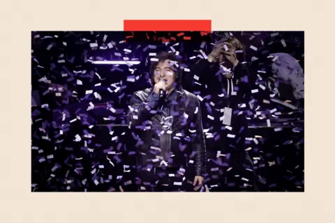 EPA/Shutterstock  Javier Milei speaks during an event with confetti surrounding him