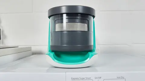 Essex inventor up for Earthshot Prize for tackling microplastics Matter One of the filters made by Adam Root's company is placed on top of a white washing machine. It is cylindrical and white, turquoise and black in colour.