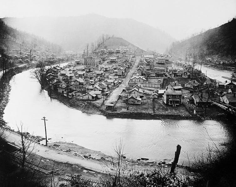 For many miners, religion and labor rights have long been connected in coal country A black and white photo of a settlement on a small hill along a river.