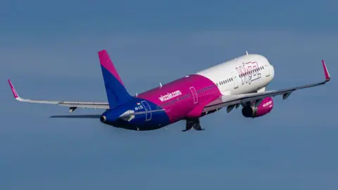 NurPhoto via Getty Images  Wizz Air Airbus A321 flying against blue sky