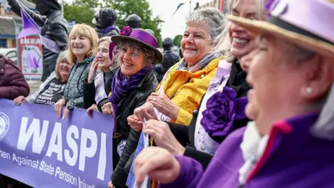 Getty Images A line of Waspi campaigners holding a banner with the name of the campaign on it.