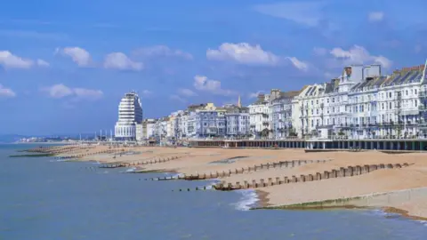 Getty Images The promenade of an English seaside town. It is sunny. There is a shingle beach. 