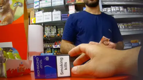 Crime network behind UK mini-marts is enabling migrants to work illegally Undercover footage which captures a customer buying illegal cigarettes.