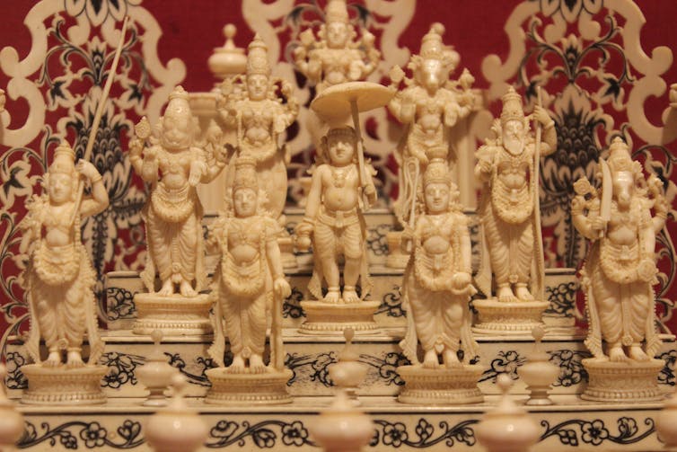 Small, intricately carved ivory statues of human and half-human, half-animal figures.