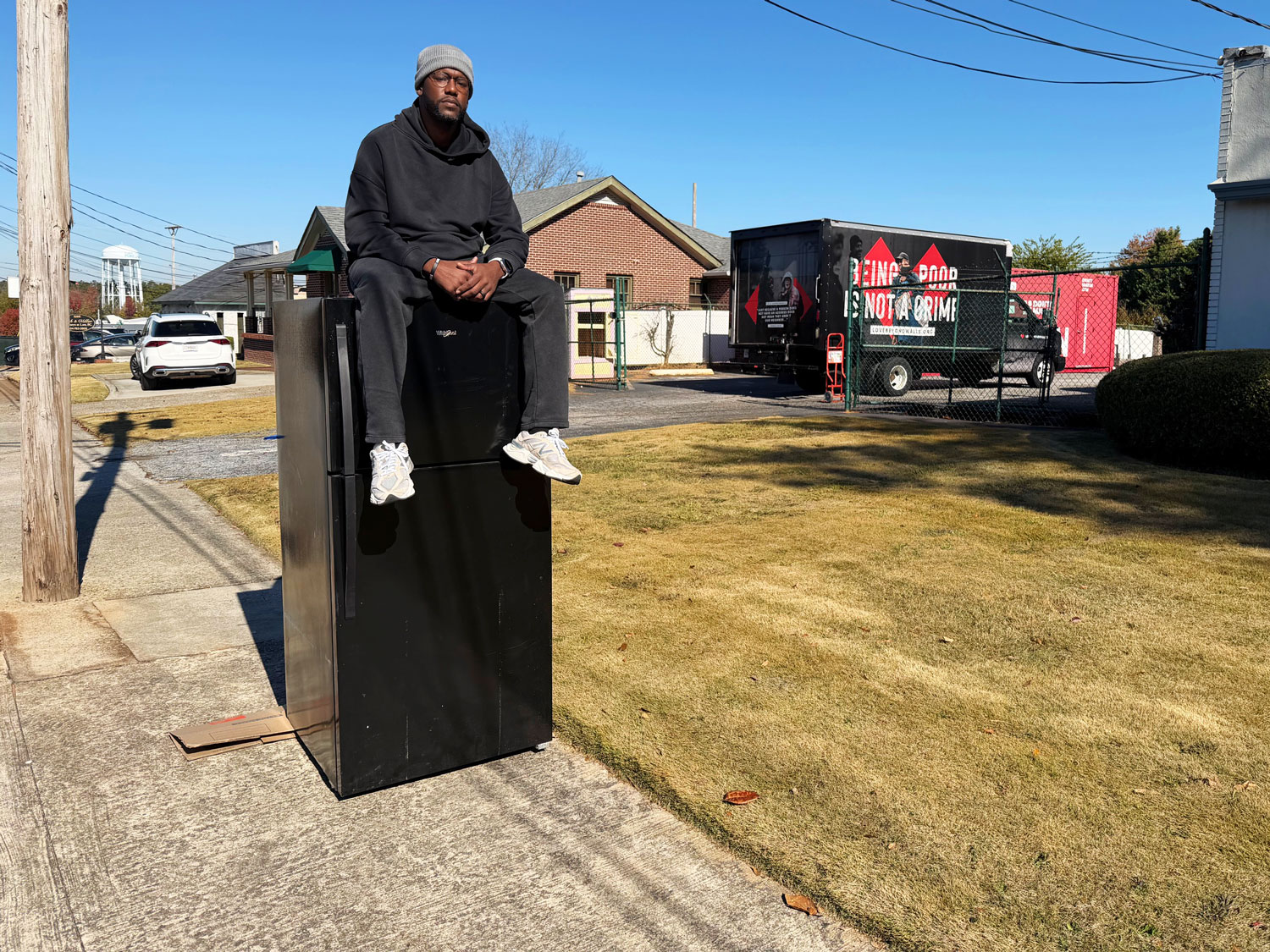 webRNS Terence Lester Fridge protest 20251107 Sitting atop fridge to protest SNAP cuts, faith leader models Jesus' 'proximity' to the poor