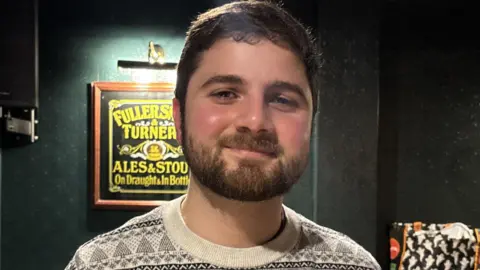 Why this month's inflation figure may be good news for you Costa Christou smiling in a Christmas jumper.