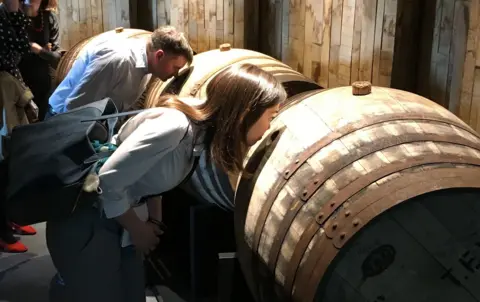 Whisky industry faces a bleak mid-winter as tariffs bite and exports stall Visitors to a distillery sniffing a barrel of maturing whisky