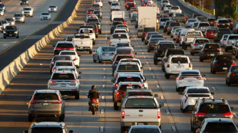 Getty Images A motorcyclist lane splits as traffic backs up on Interstate 5 during the afternoon commute on November 7, 2025 in San Diego CA.