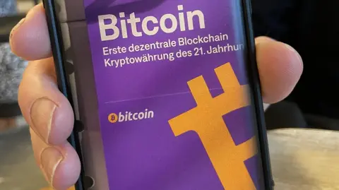 The Swiss city that lets you pay for most things with bitcoin A man showing an app on his mobile phone that allows him to pay in bitcoin