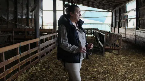 Anastasia Siourtou walking through her empty barn