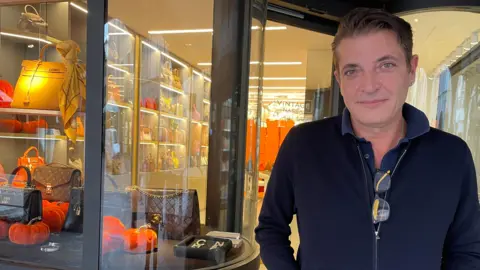 The Swiss city that lets you pay for most things with bitcoin Shopkeeper Cerubino Fry standing outside of his store