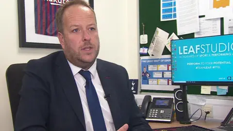 Leaf Studio Academy Headteacher, Tim Clark, sitting in his office. 