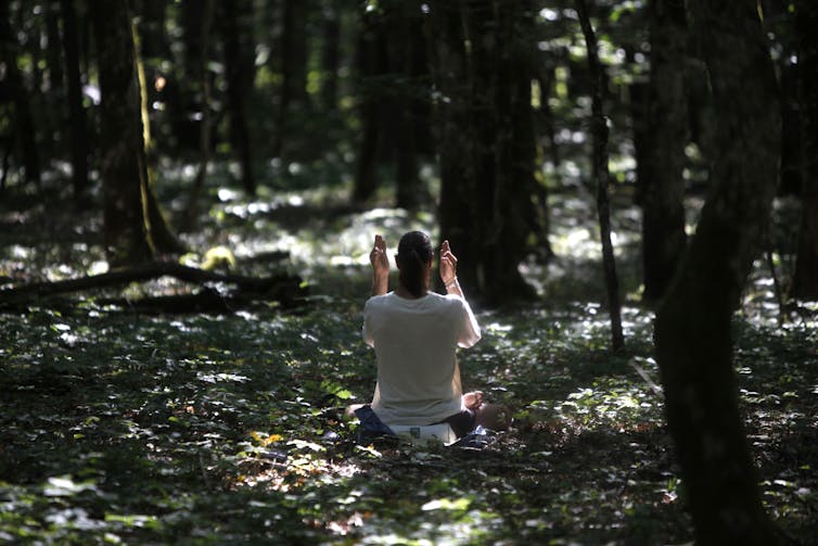 Outside the West, the Kundalini tradition presents a model of the ‘divine feminine’ beyond binary gender A woman meditates in the forest.